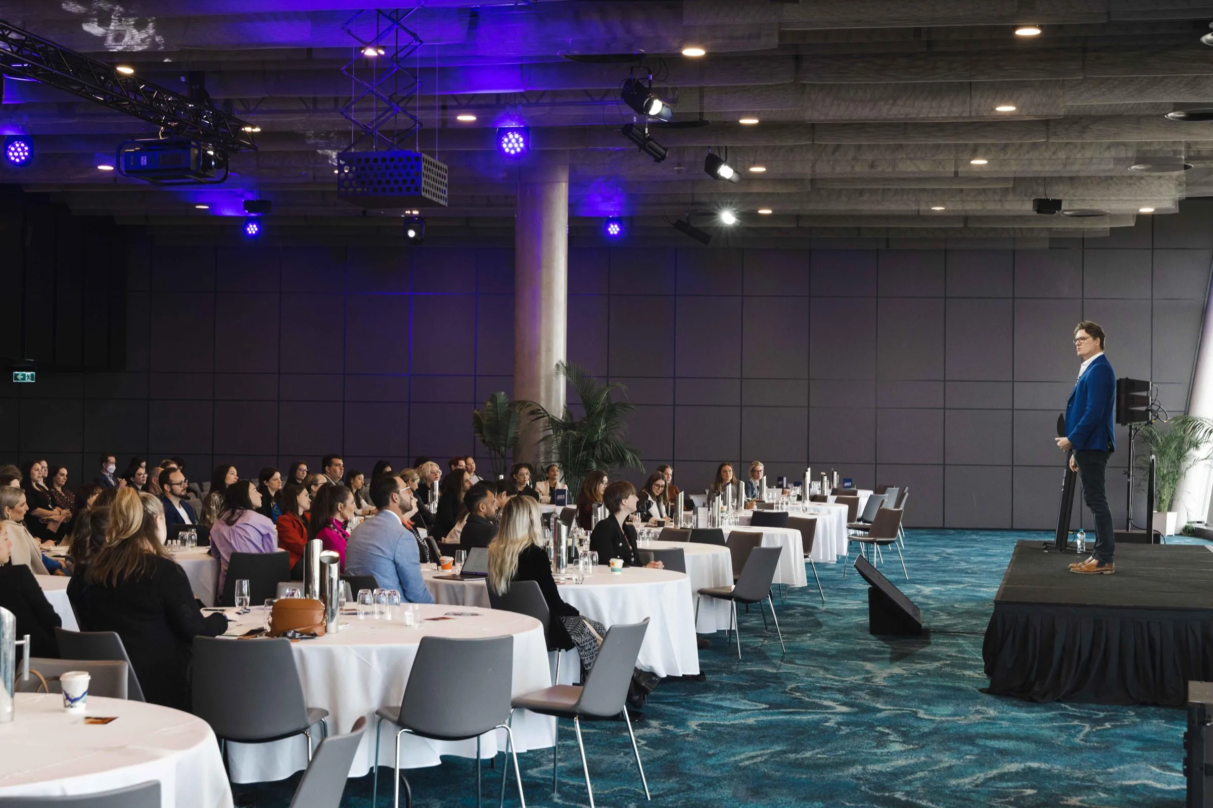 Keynote speaker addressing a seated audience at a corporate conference dinner